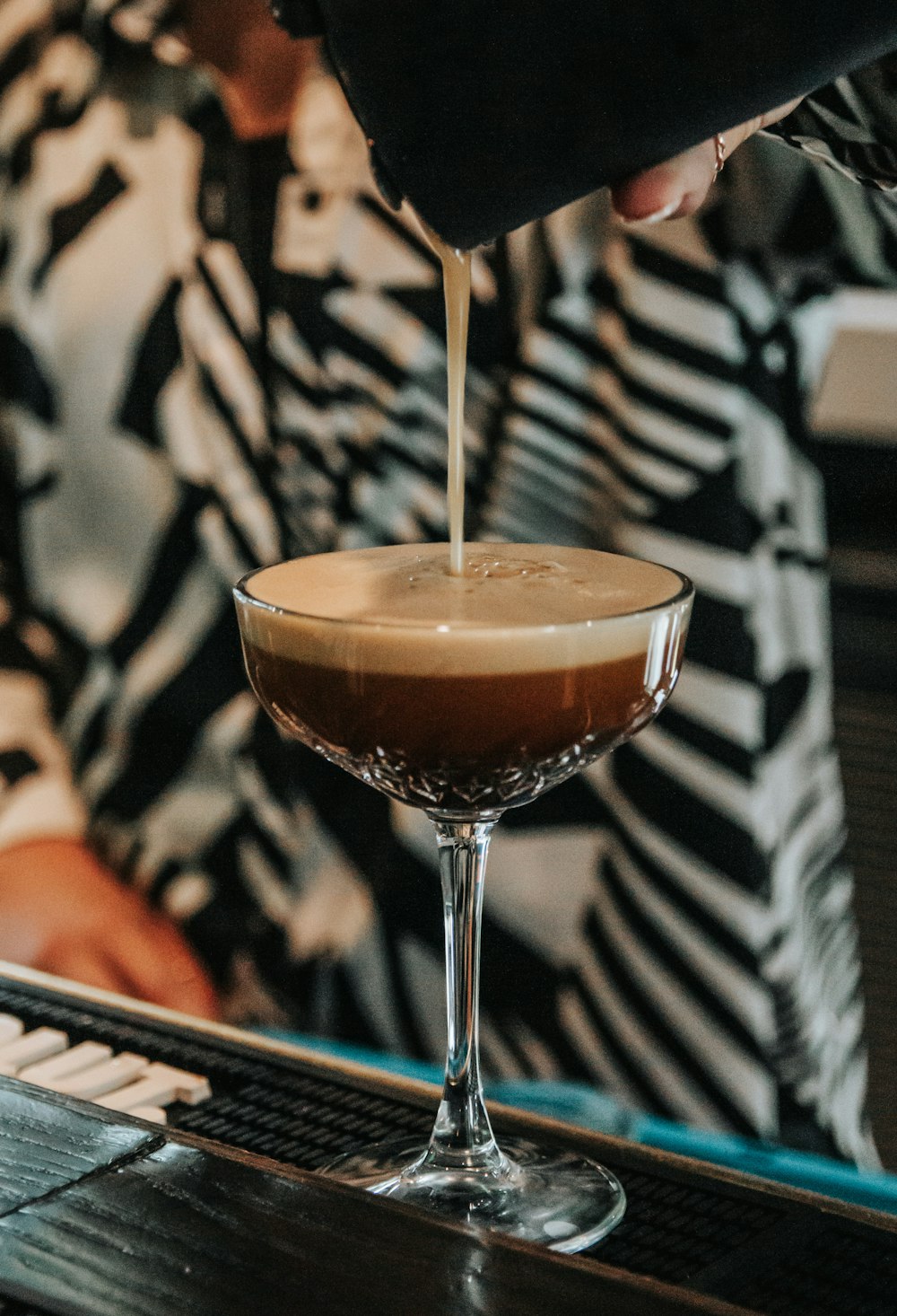 a person pouring a drink into a glass