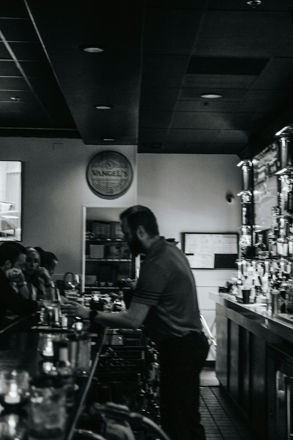 a black and white photo of a man at a bar