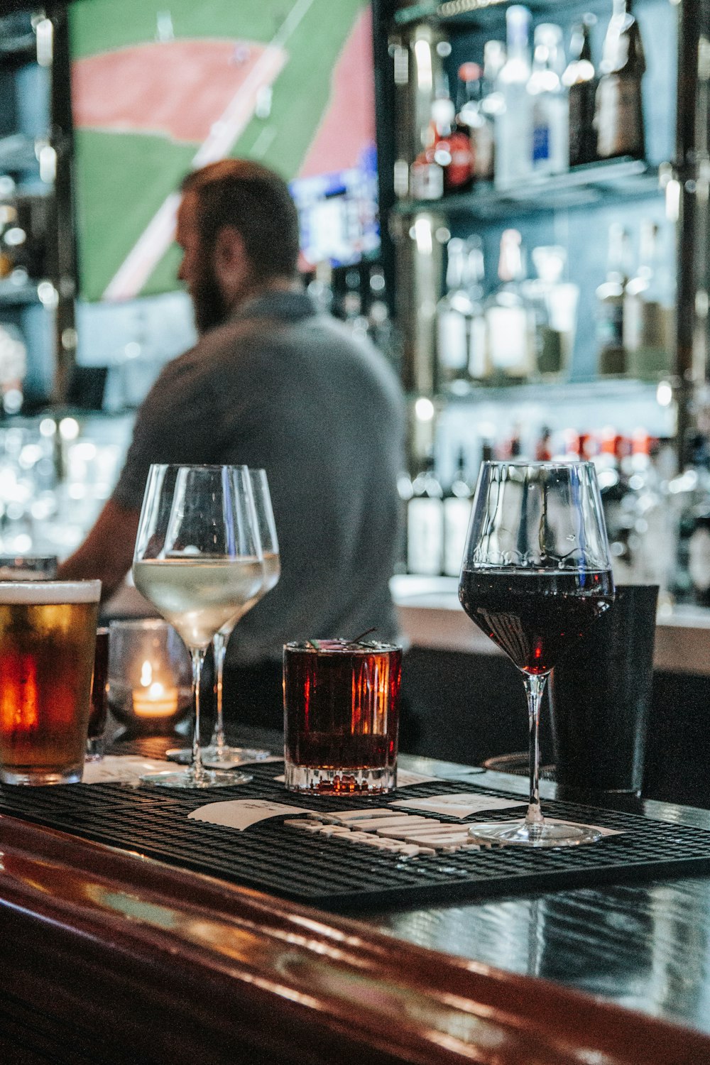 a man sitting at a bar with three glasses of wine