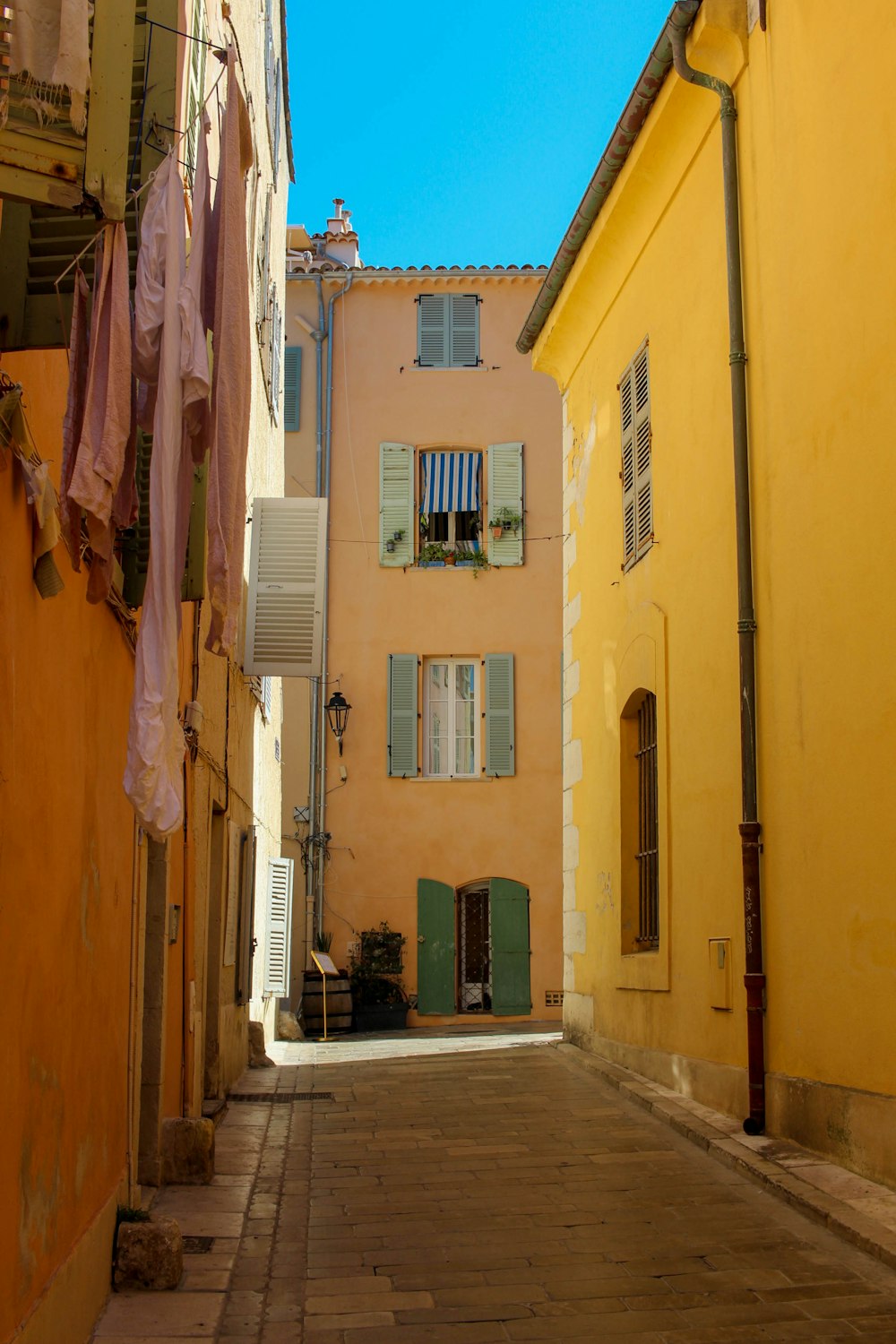 a narrow alley with clothes hanging out to dry