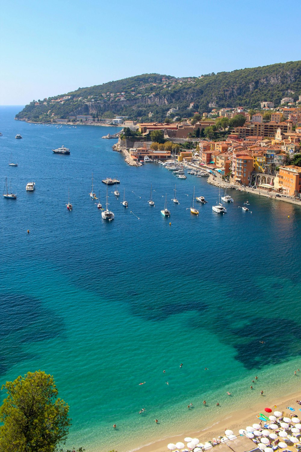 a beach with many boats in the water