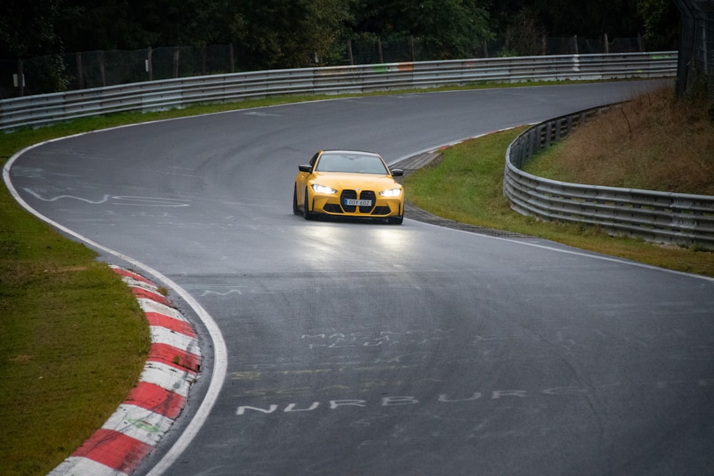 a yellow sports car driving on a race track