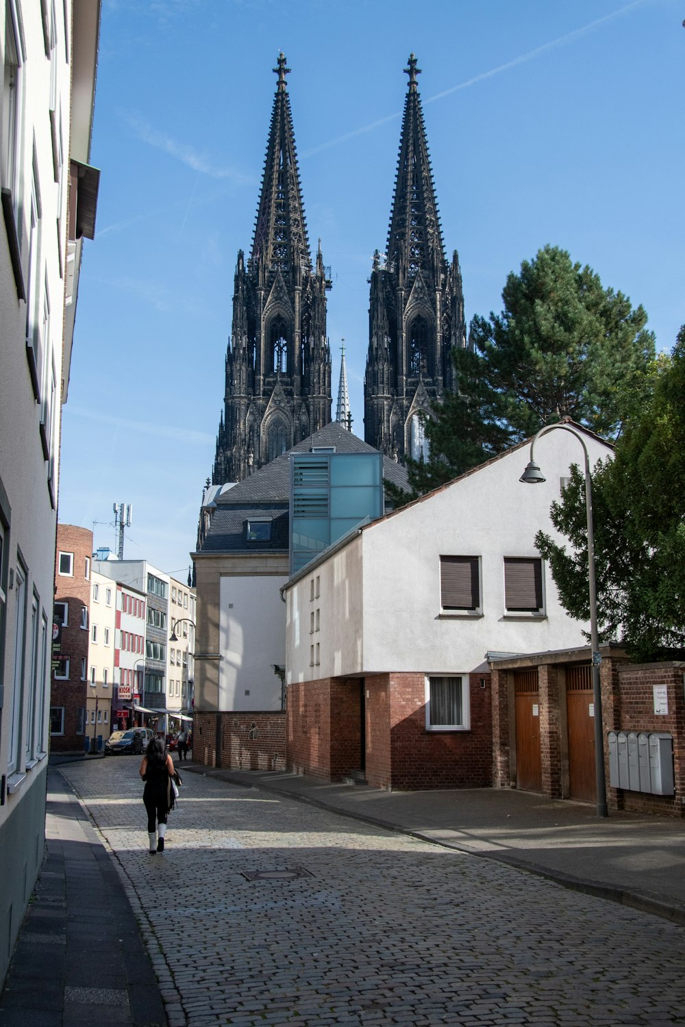 a person walking down a street in front of a church