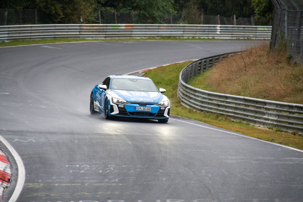 a blue car driving down a race track