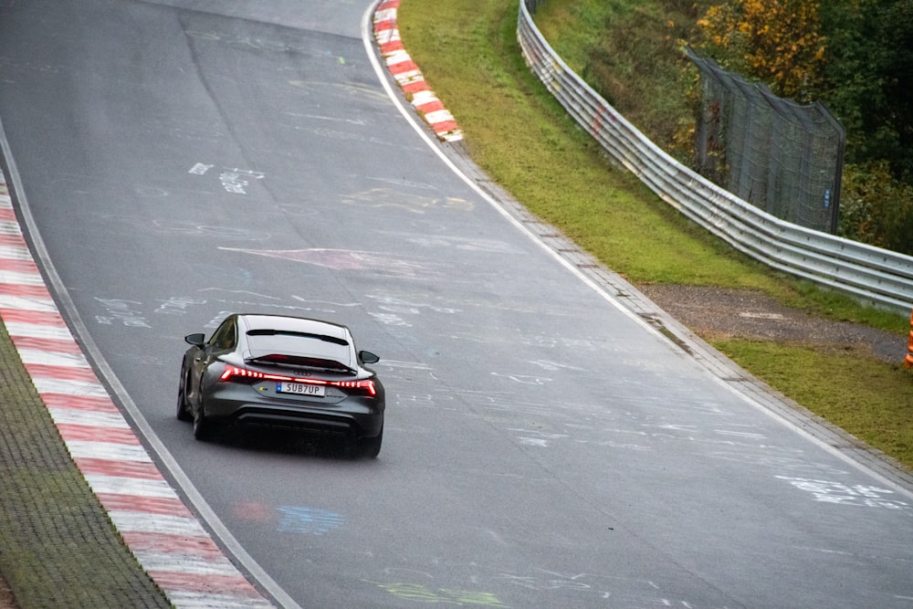 a black sports car driving down a race track