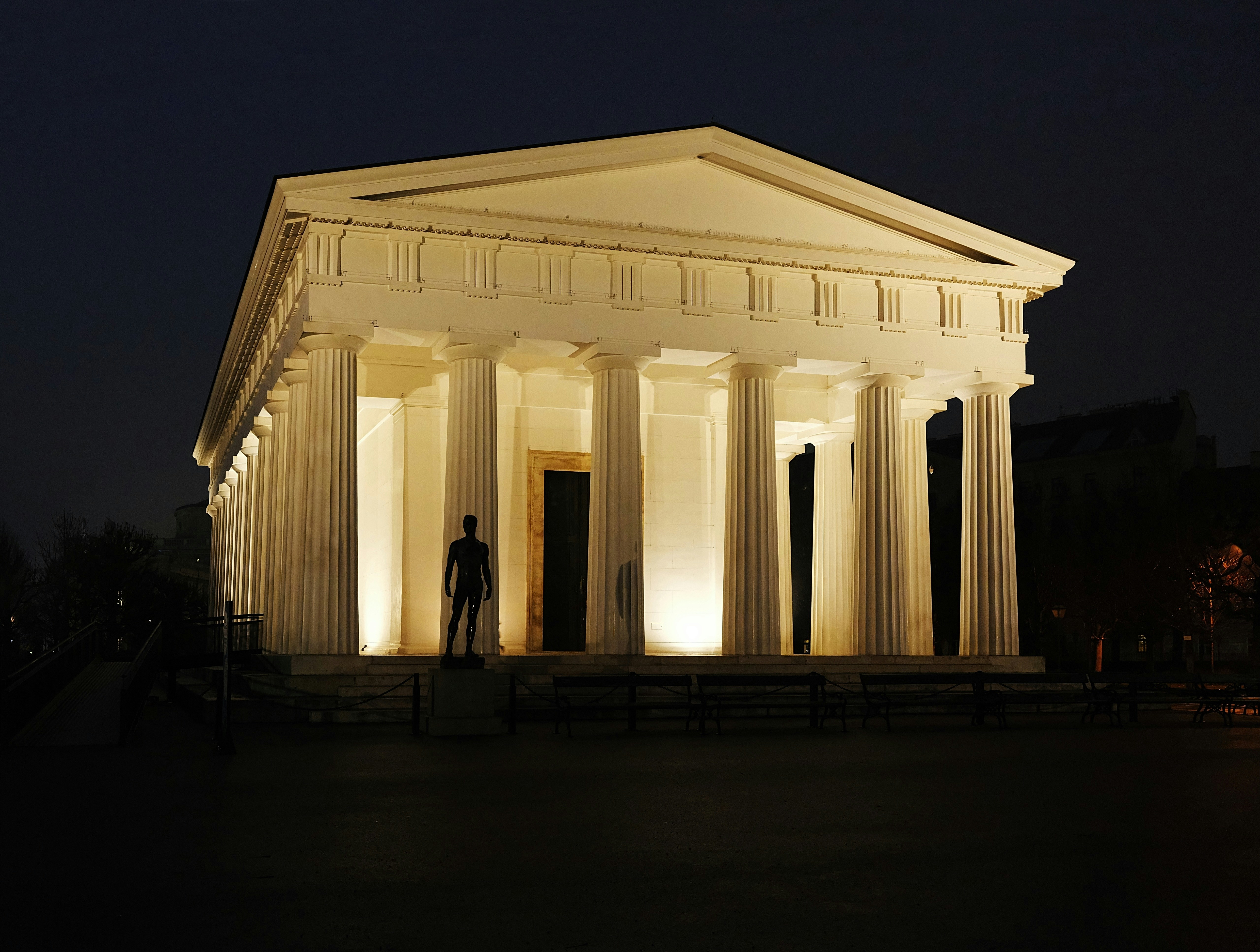 a man standing in front of a white building, A classic architecture in Vienna