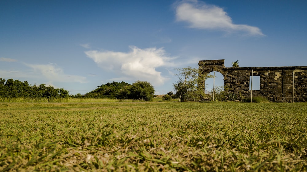 a stone building in a field with trees in the background