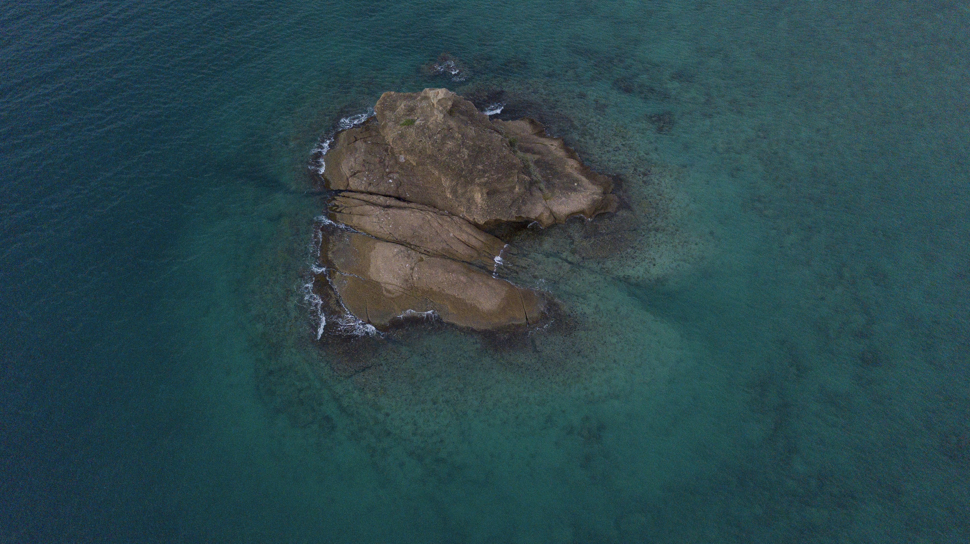 an aerial view of a rock formation in the ocean