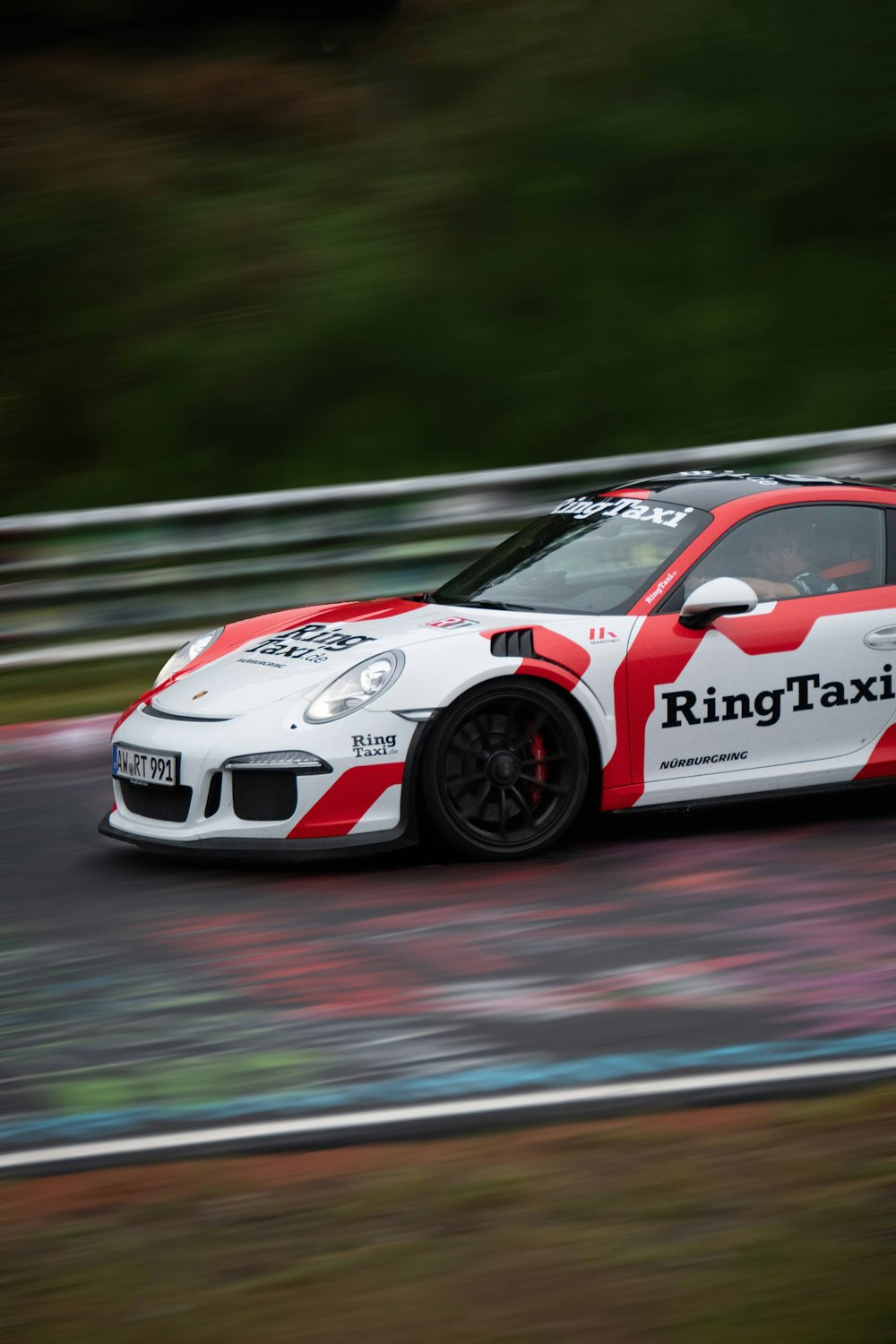 a white and red car driving down a race track