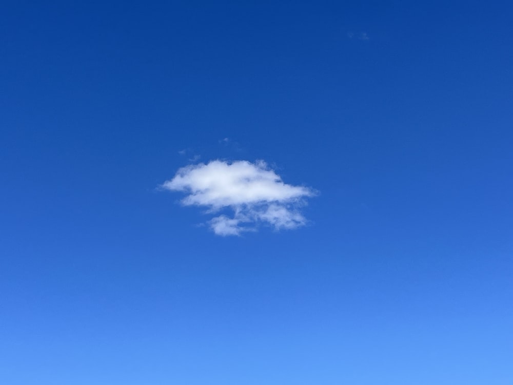 a white cloud floating in a blue sky