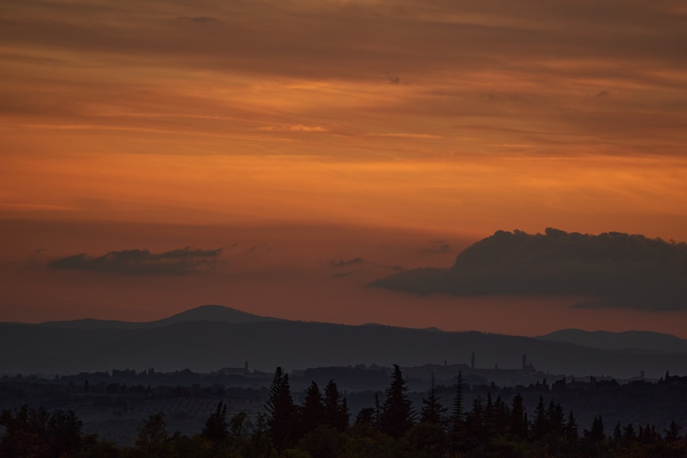 the sun is setting over a mountain range