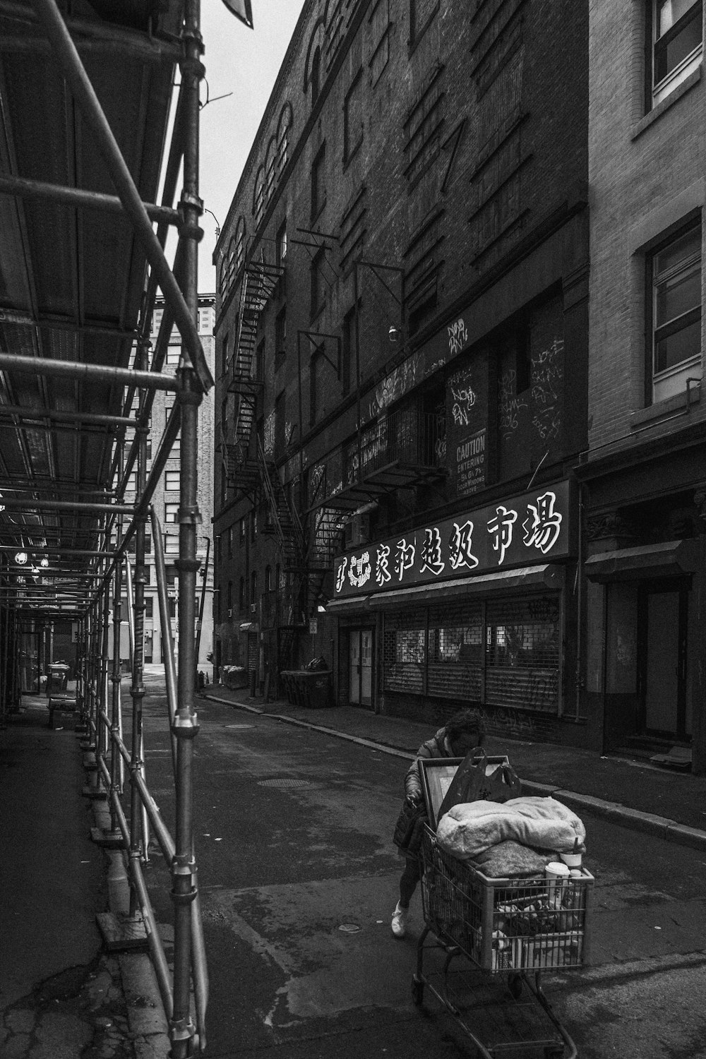 a man pushing a shopping cart down a street