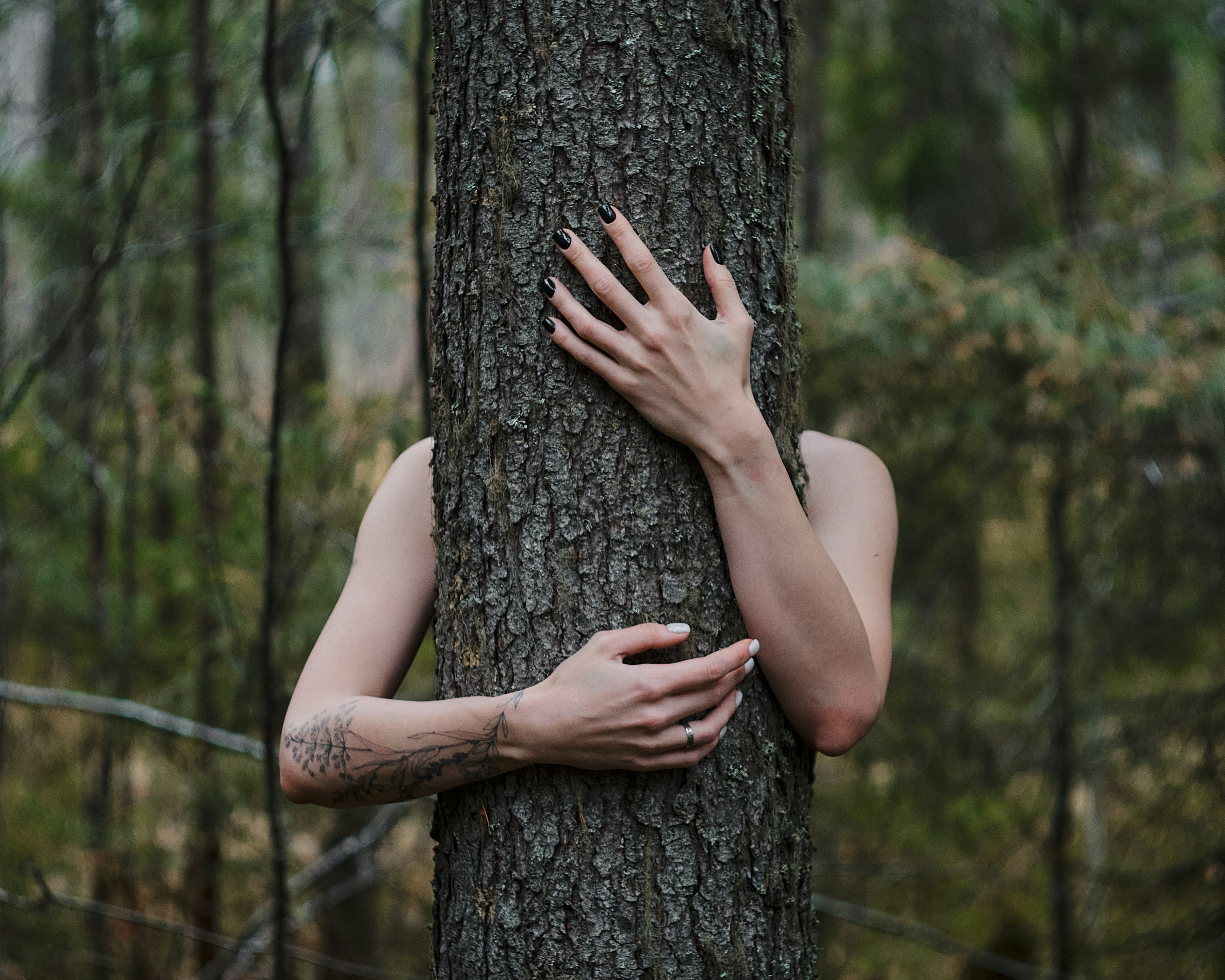 a woman hugging a tree in a forest