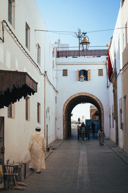 a man in a white robe walking down a street
