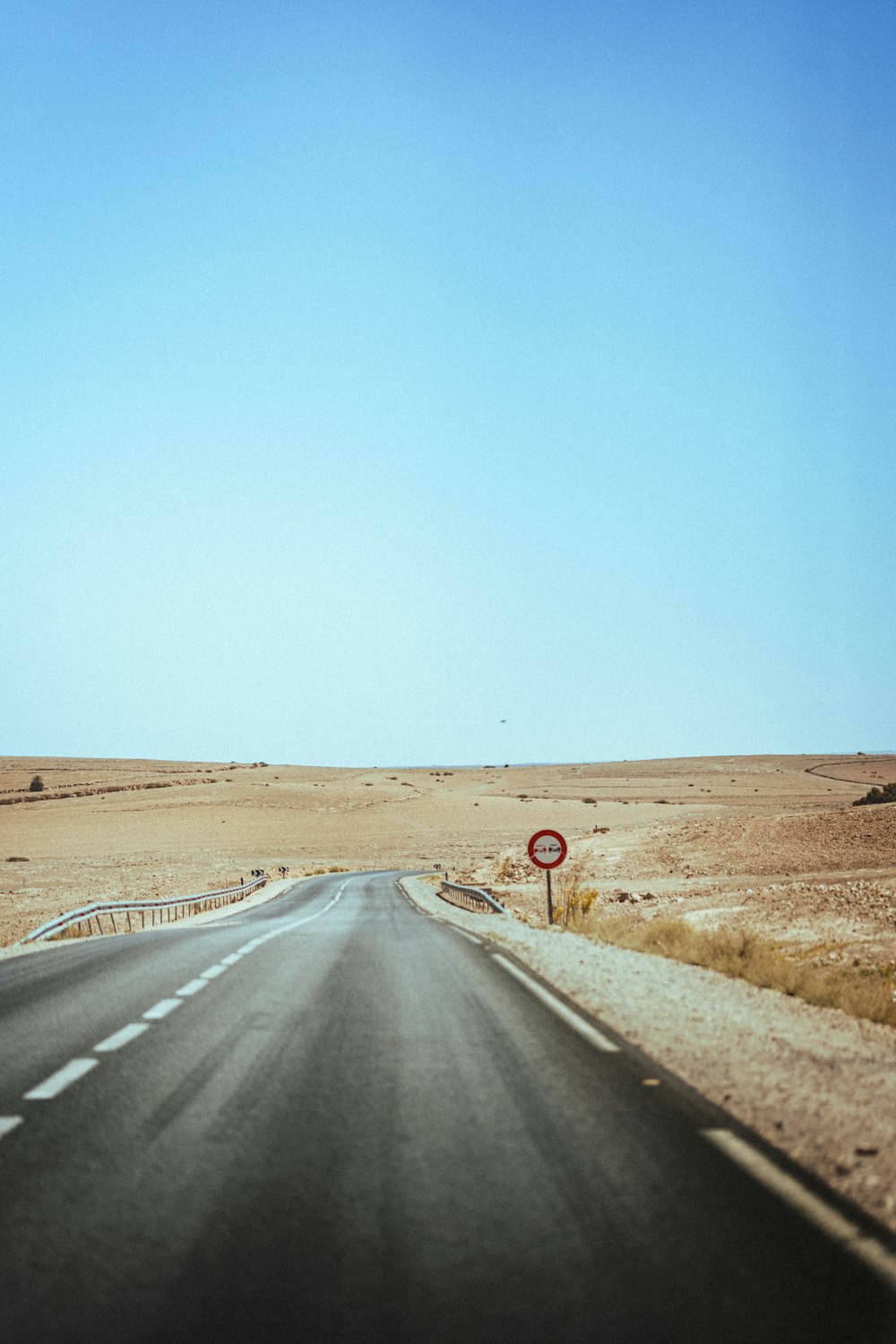 an empty road in the middle of a desert