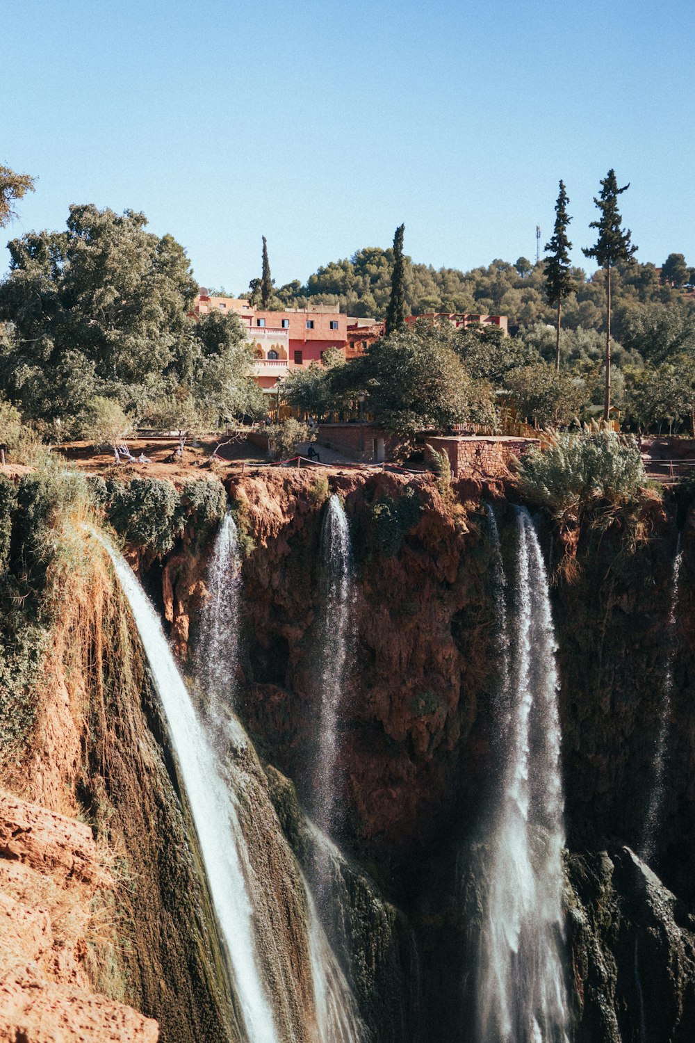 a large waterfall with a bridge above it