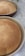 Two freshly baked, golden brown loaves of bread sit in round baking pans on a speckled countertop. The bread is evenly baked, creating a smooth and slightly domed surface.