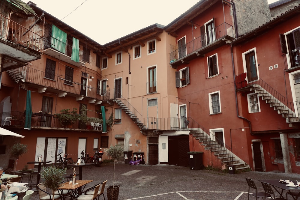 a courtyard with tables, chairs, and stairs