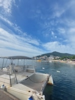 A Fontaine Pajot catamaran docked in a vibrant marina with colorful buildings in the background.