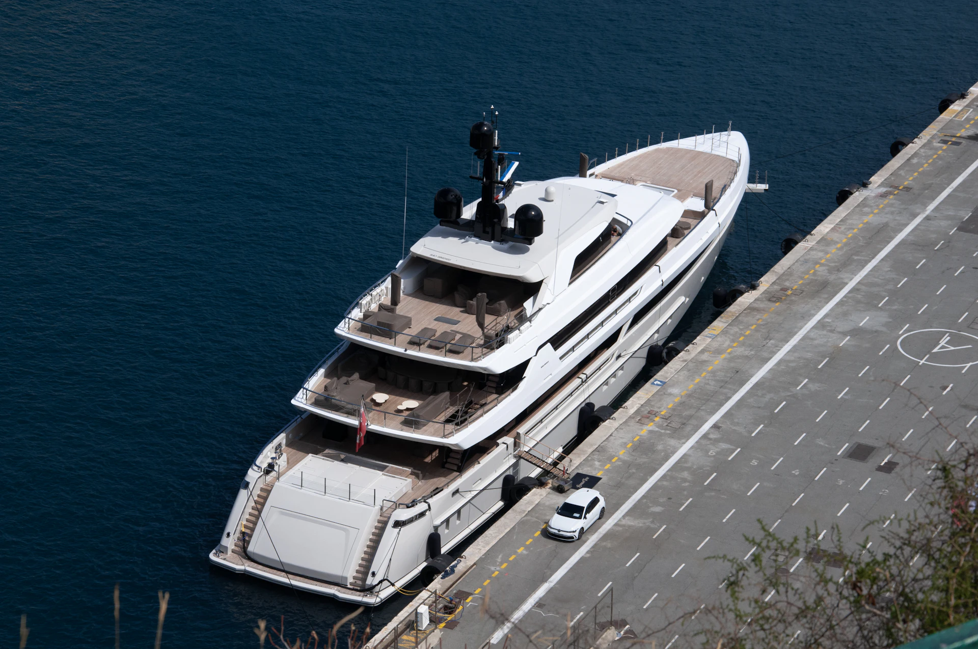 Aerial view of a modern superyacht moored alongside a quay