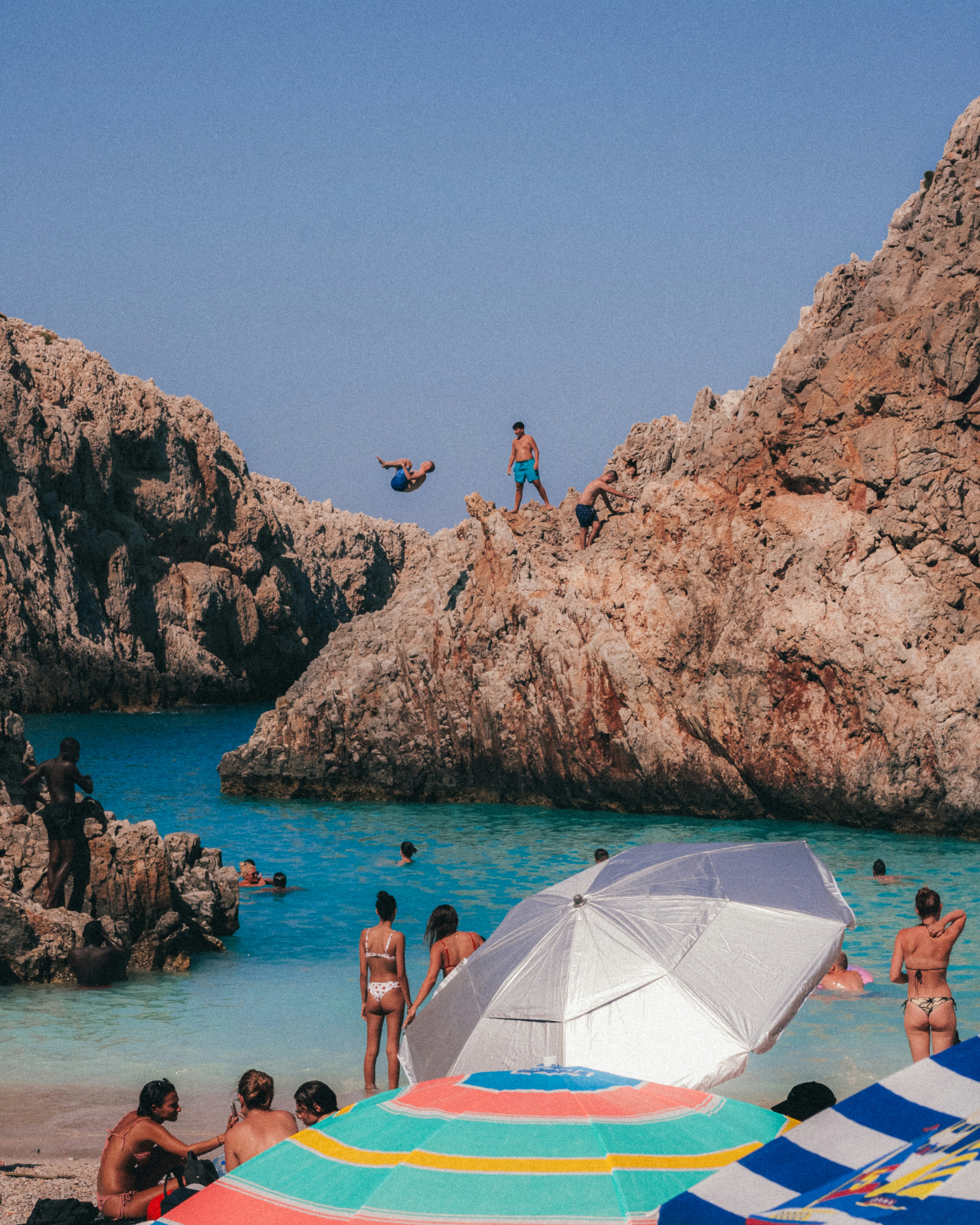 a group of people standing on top of a sandy beach
