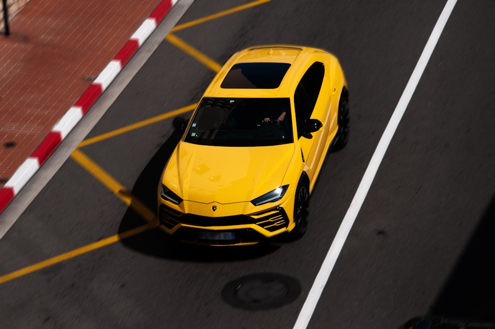 a yellow sports car driving down a street