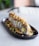 A beautifully plated sushi roll with vibrant colors and fresh ingredients on a wooden table.