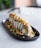 A beautifully plated sushi roll with vibrant colors and fresh ingredients on a wooden table.