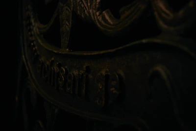 A close-up of a vintage astrolabe casting intricate shadows on a dark surface.