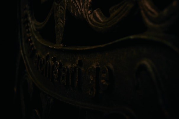 Close-up of cryptic symbols etched on a metallic surface illuminated by soft blue light.