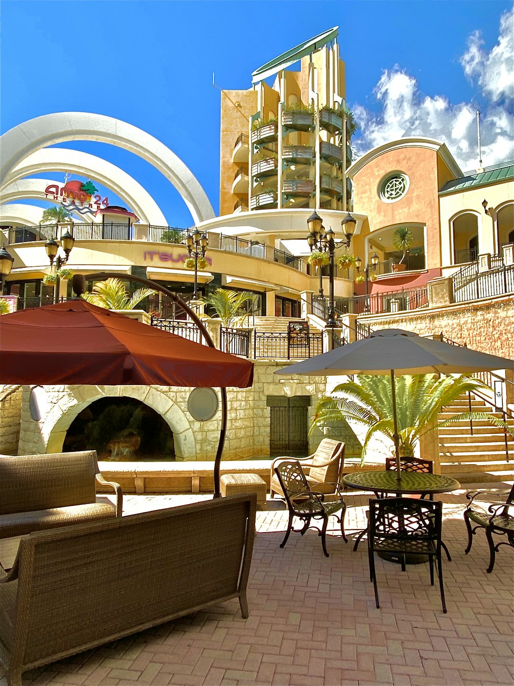 a patio area with tables and chairs and umbrellas