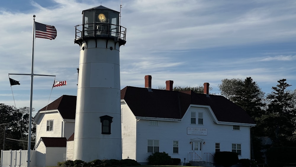 a white lighthouse with a clock on top of it