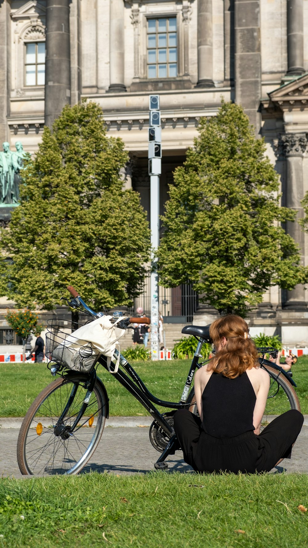 a woman sitting on the ground next to a bike