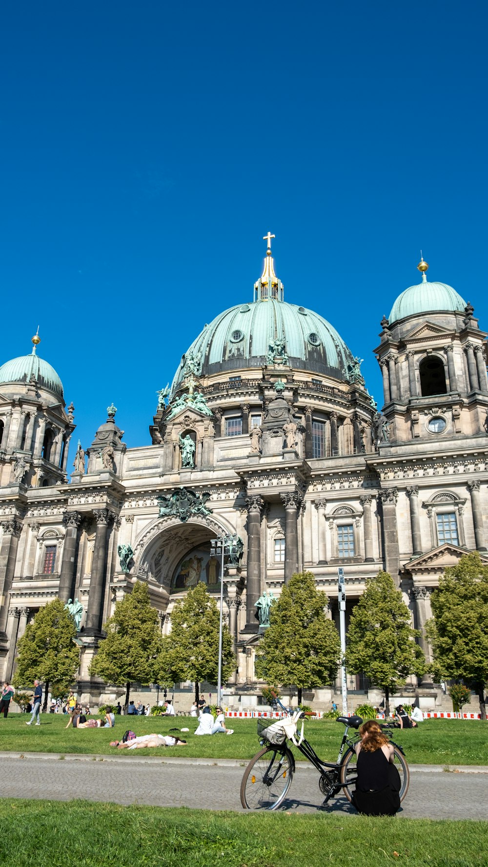 eine Person, die auf einer Bank vor einem großen Gebäude sitzt