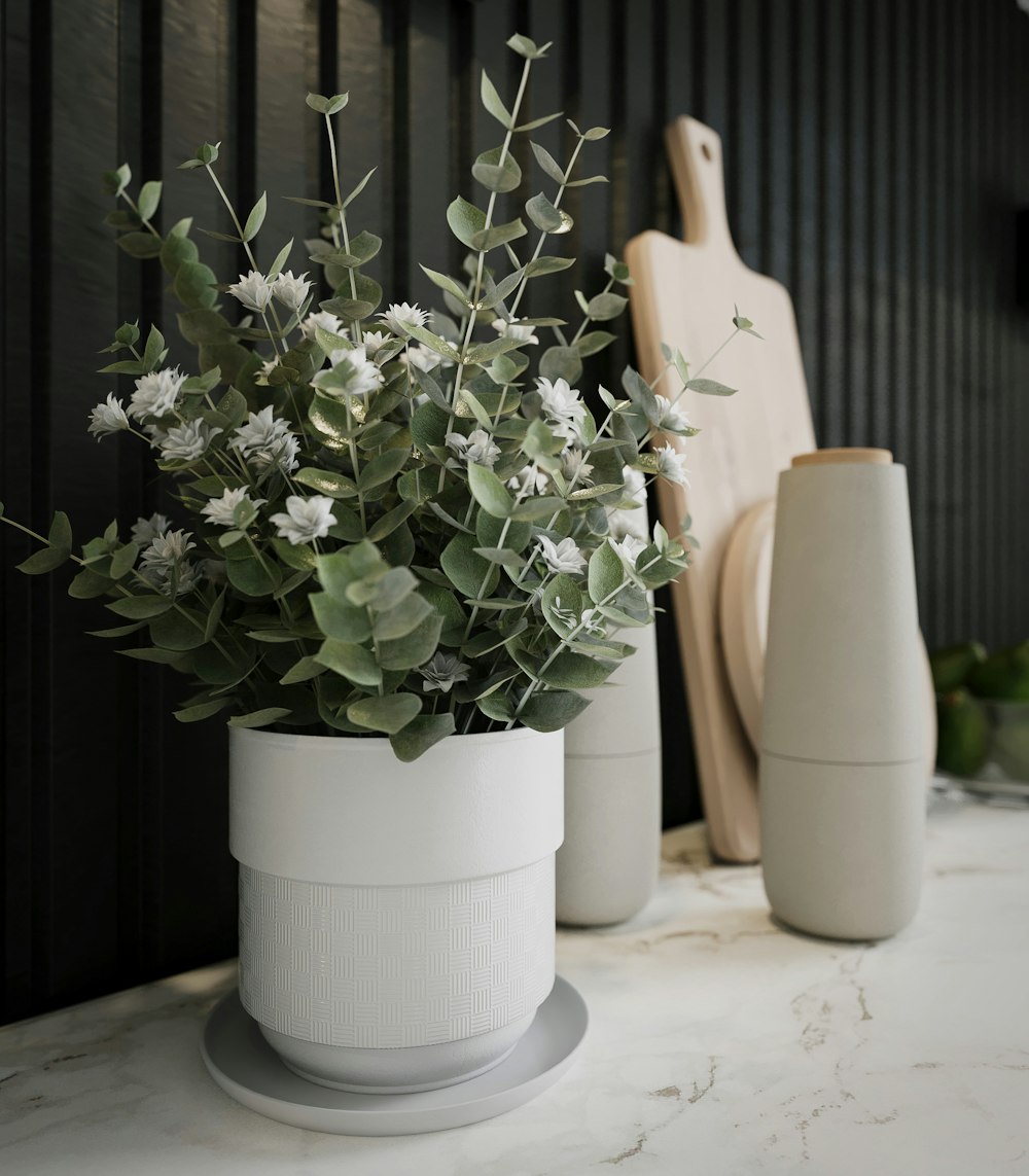 a white vase filled with flowers on top of a counter