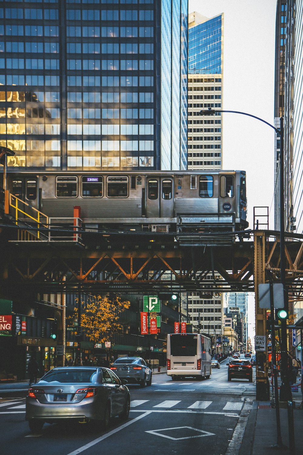 a train traveling over a city street next to tall buildings