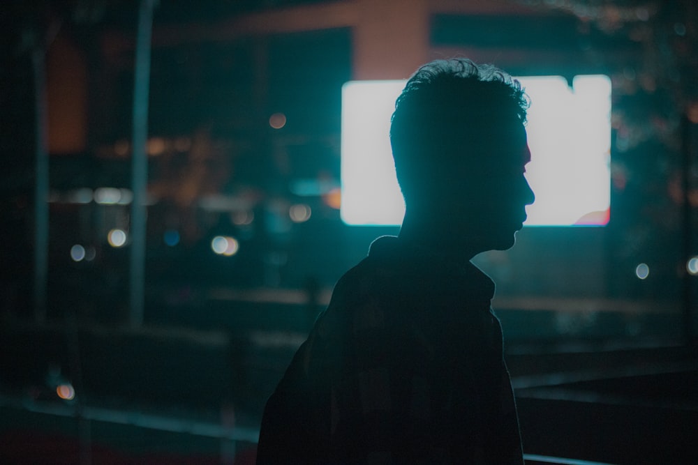 a man standing in front of a tv in the dark