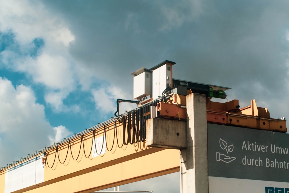 a sign on a bridge with a cloudy sky in the background