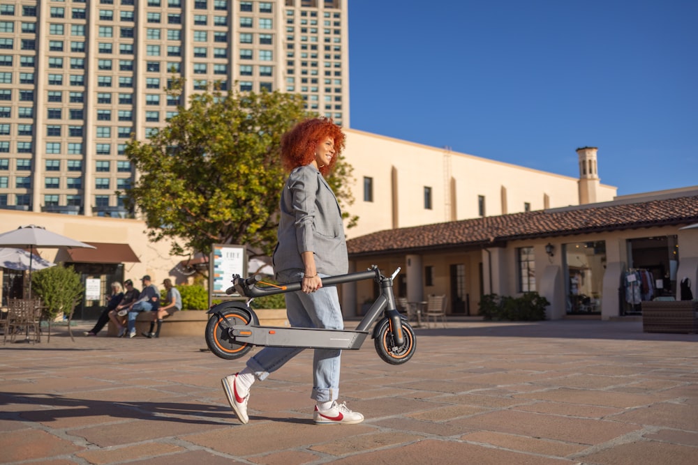 a woman with red hair is walking with a bike