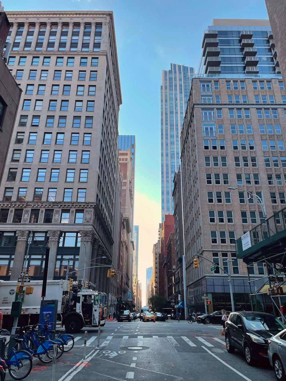 a city street lined with tall buildings and parked cars