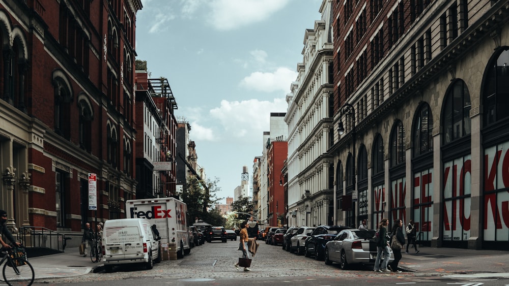 a man walking down a street next to tall buildings