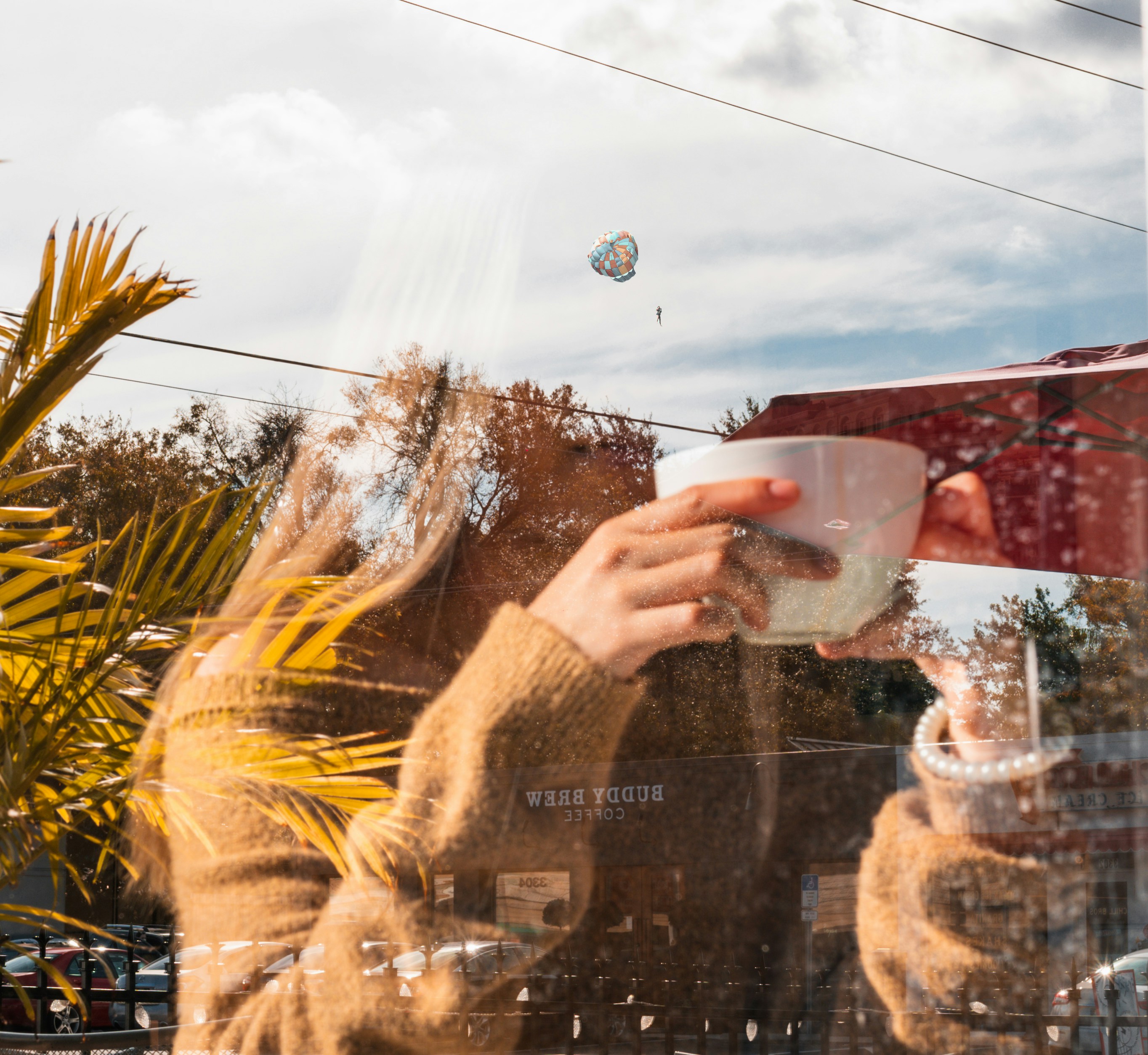 a woman holding a coffee cup in front of a window