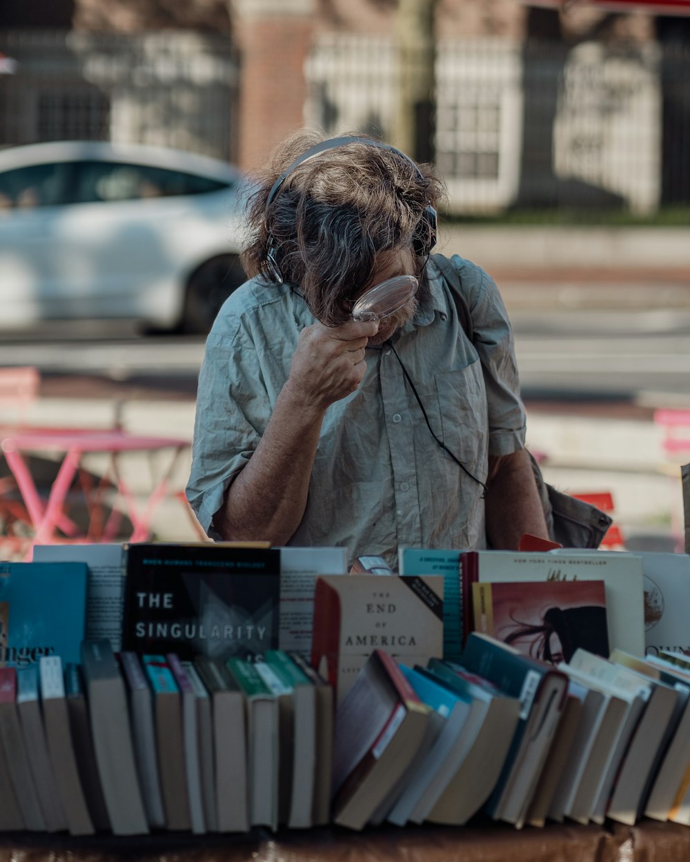 a man talking on a cell phone next to a table full of books