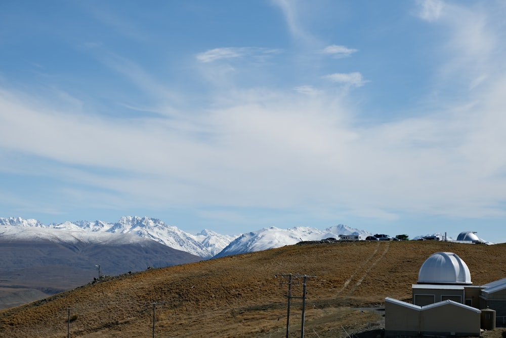 a telescope on a hill with mountains in the background