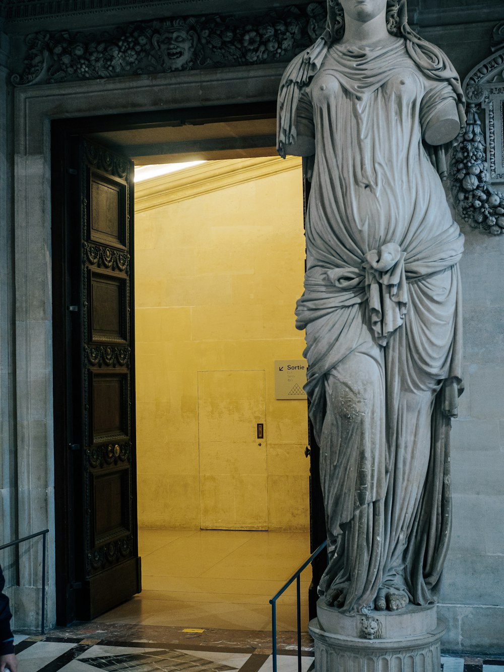 a statue of a woman standing in front of a doorway
