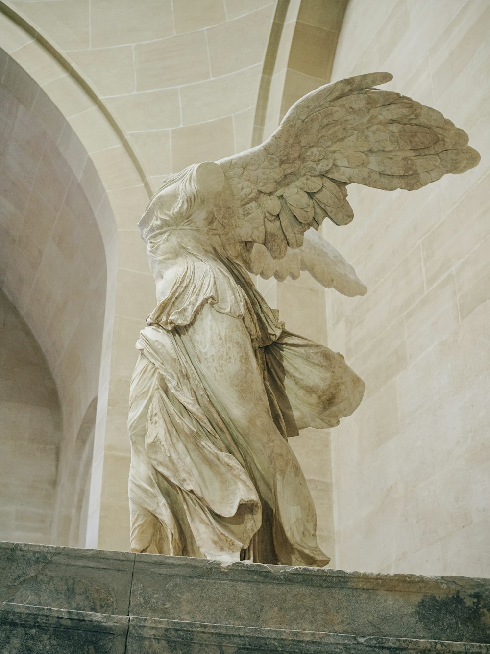 una statua di un angelo su una sporgenza in un edificio