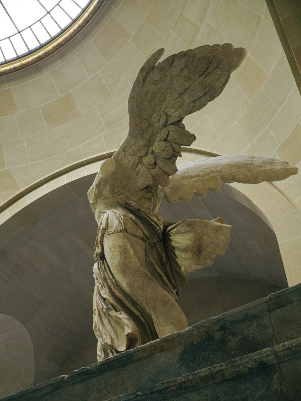 une statue d’un ange tenant un morceau de papier