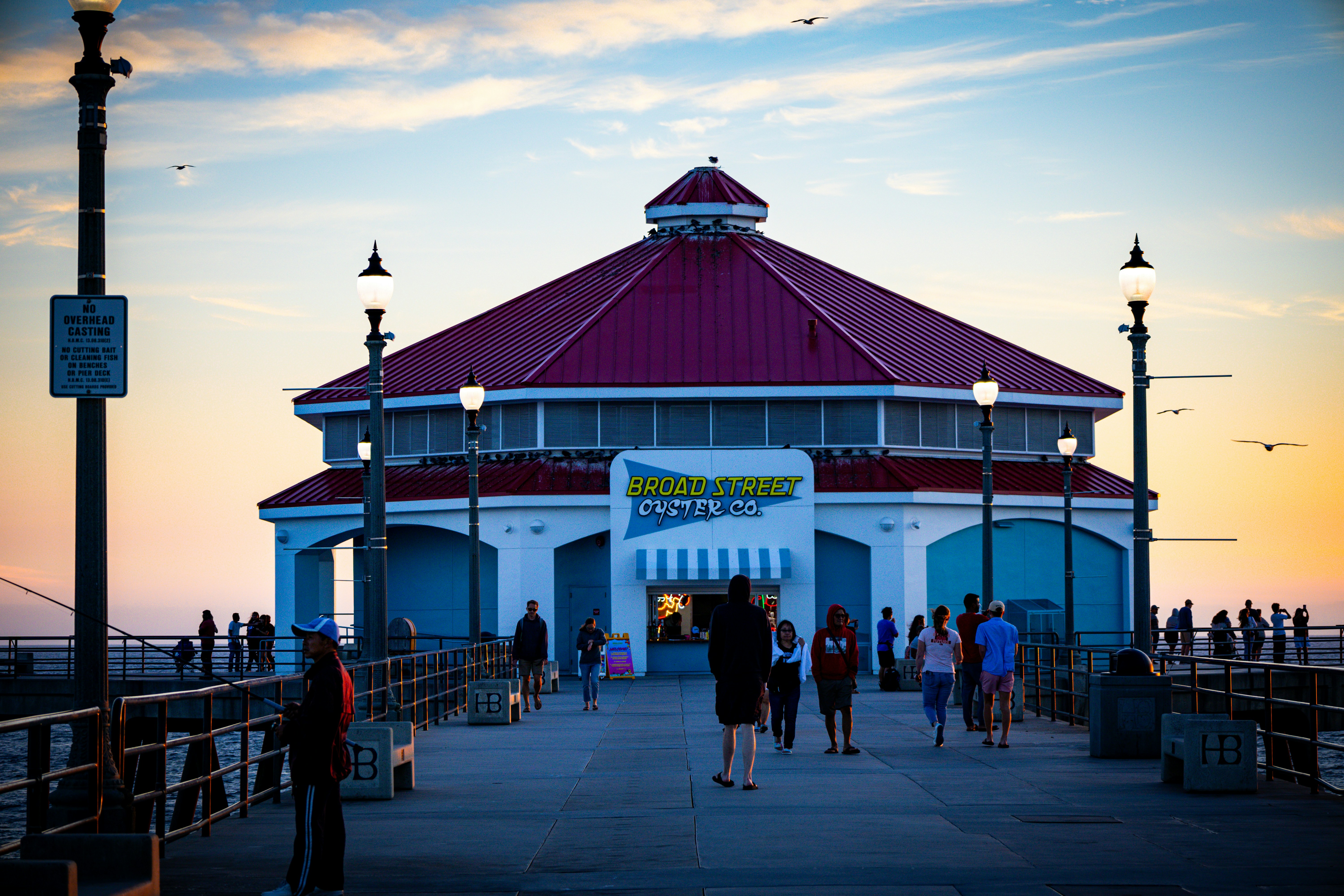 a group of people standing on a pier next to a building