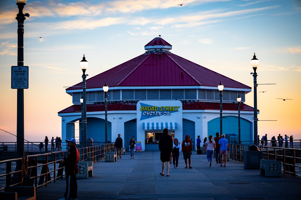 a group of people standing on a pier next to a building