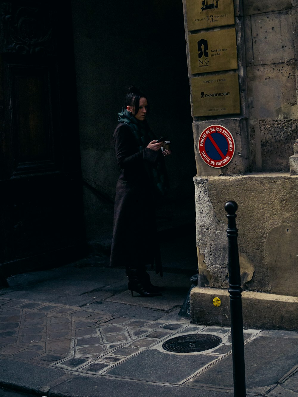 a man standing in front of a building looking at his cell phone